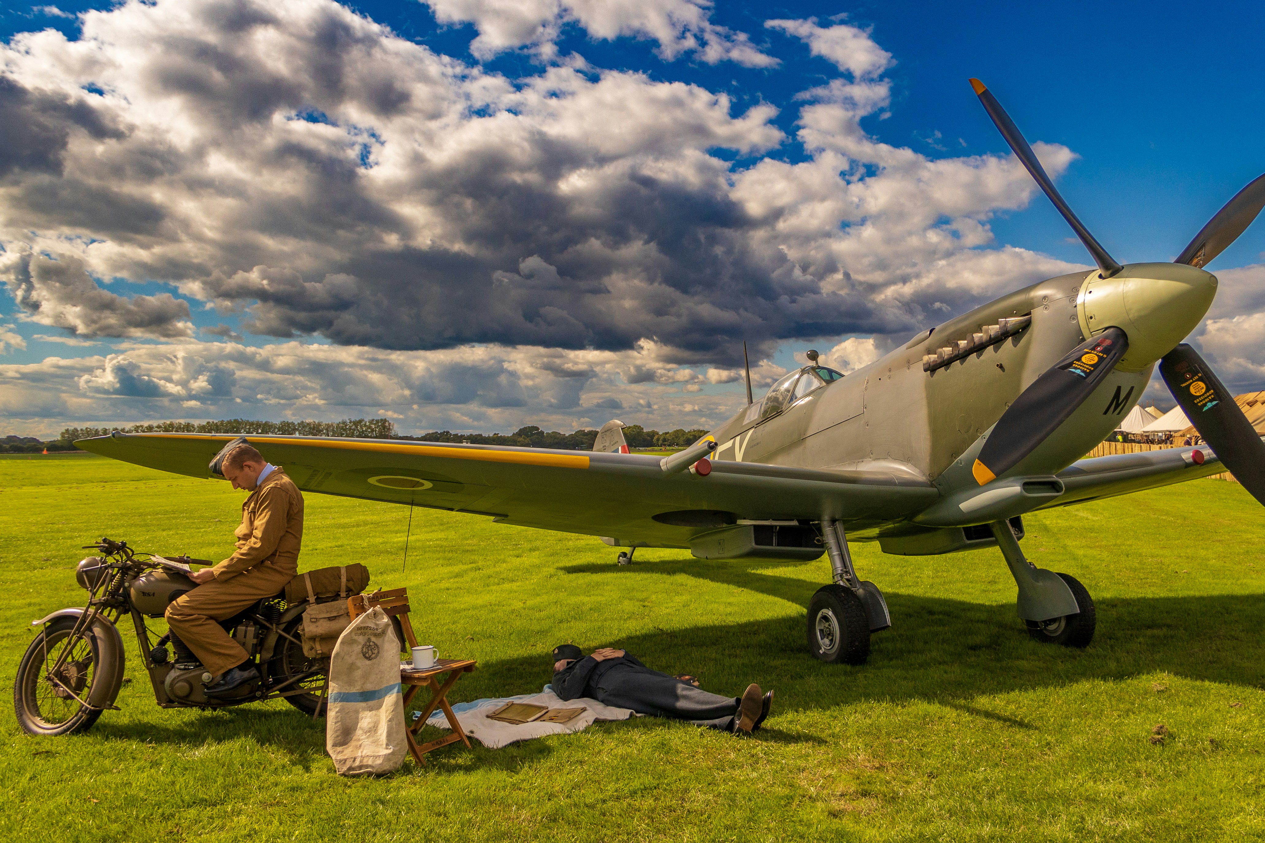 a man sitting on a motorcycle next to a plane