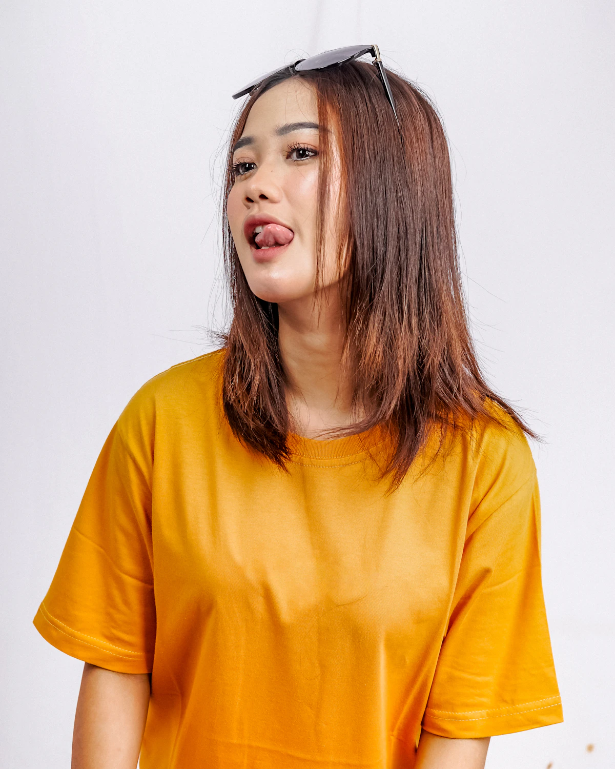 Woman in a yellow boxy cotton t-shirt and sunglasses
