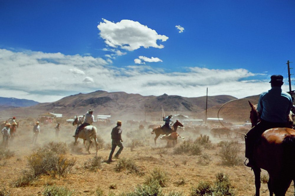 um grupo de homens cavalgando a cavalo através de um deserto