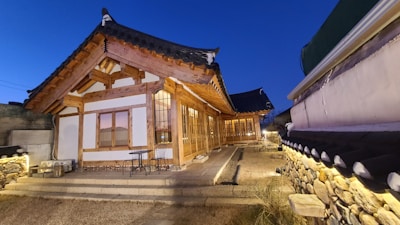 Traditional Thai wooden house exterior with warm lighting in the evening.