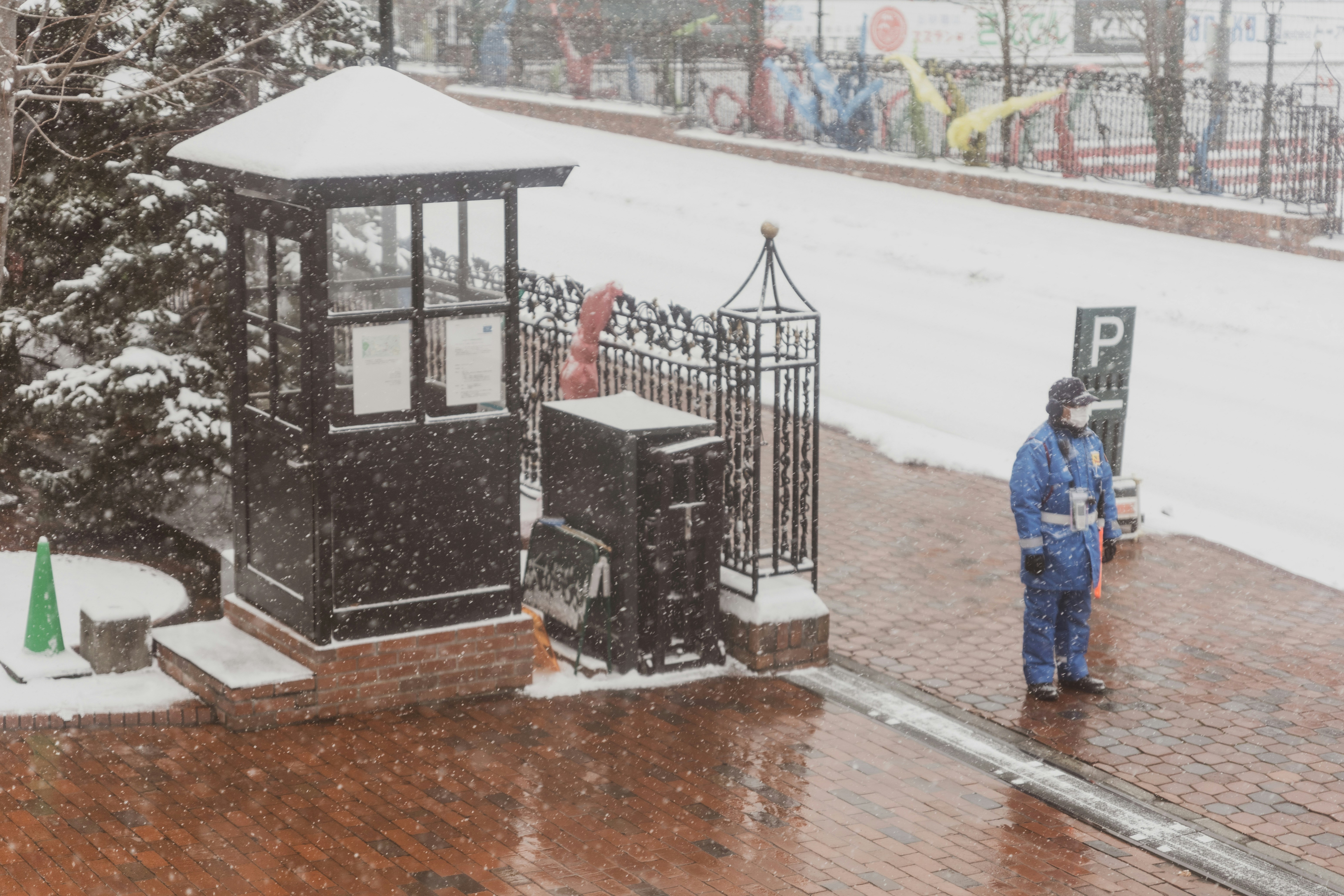 a person standing on a sidewalk in the snow