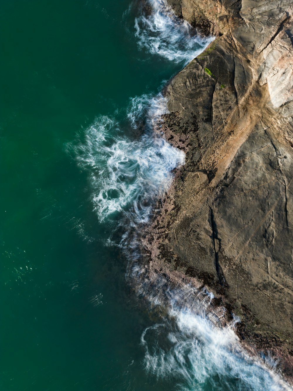 a bird's eye view of the ocean and rocks