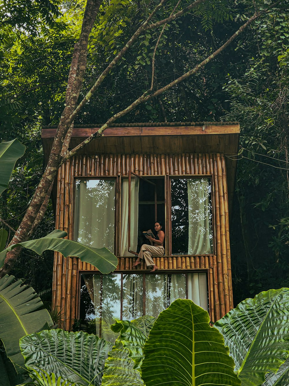 a man sitting on a window sill in a tree house