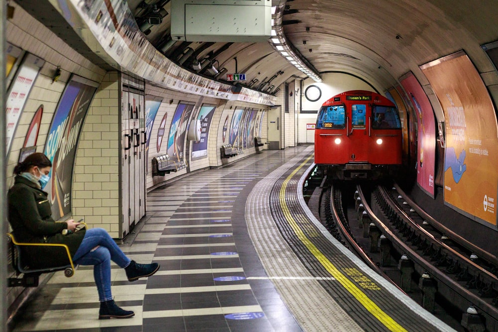 a man sitting on a bench next to a train