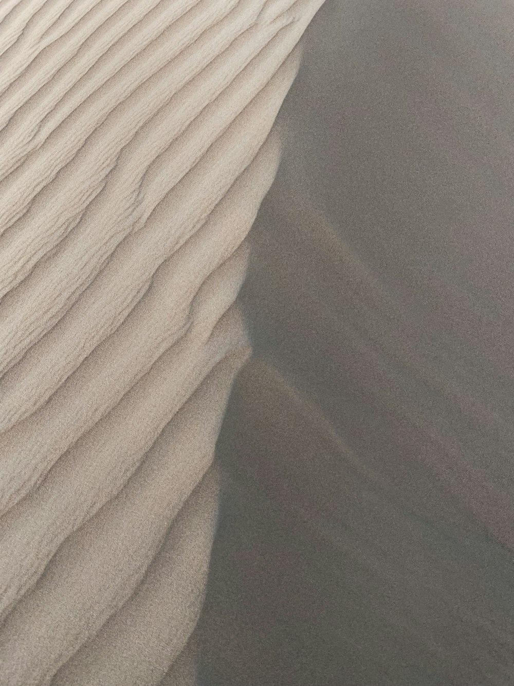 a person riding a snowboard on top of a sand dune