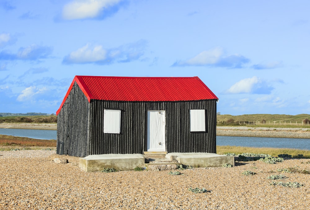 a small black building with a red roof