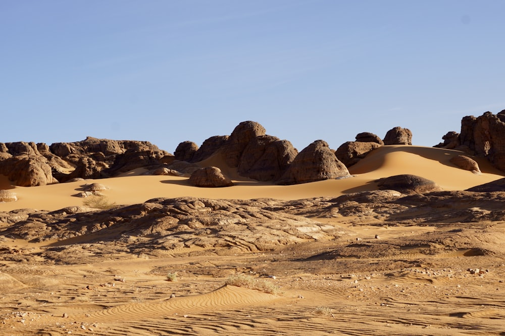 um grupo de rochas e dunas de areia no deserto