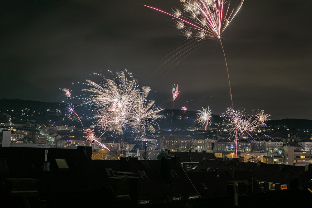 fireworks are lit up in the night sky above a city