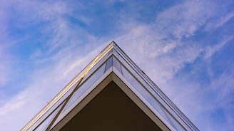 Wide shot of a modern steel frame building rising against a clear blue sky.