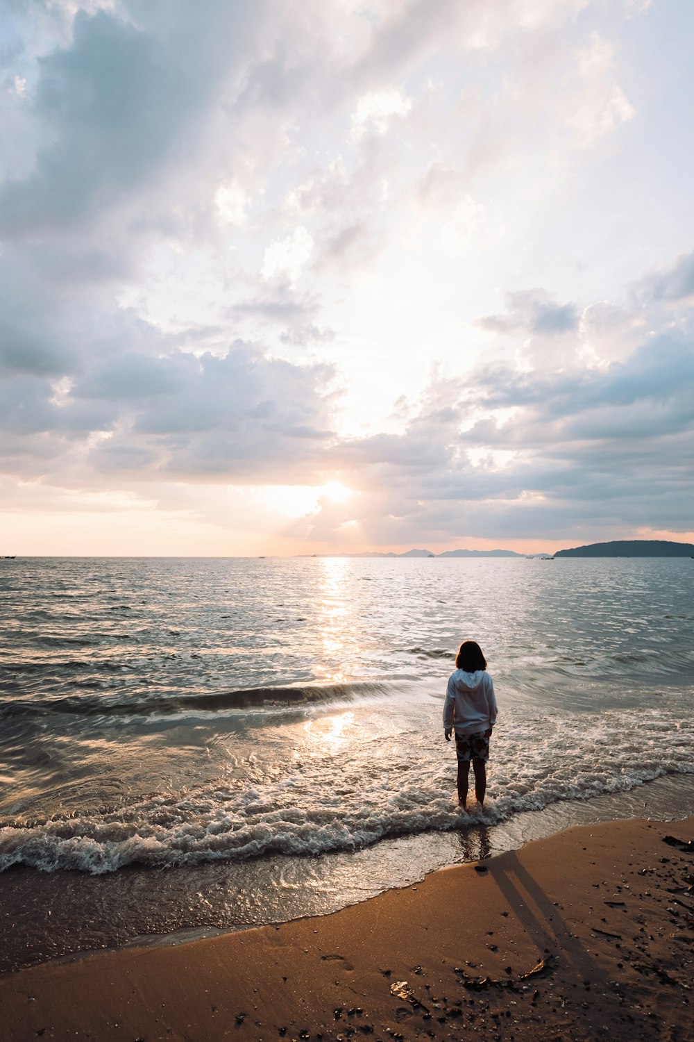 a person standing on a beach next to the ocean