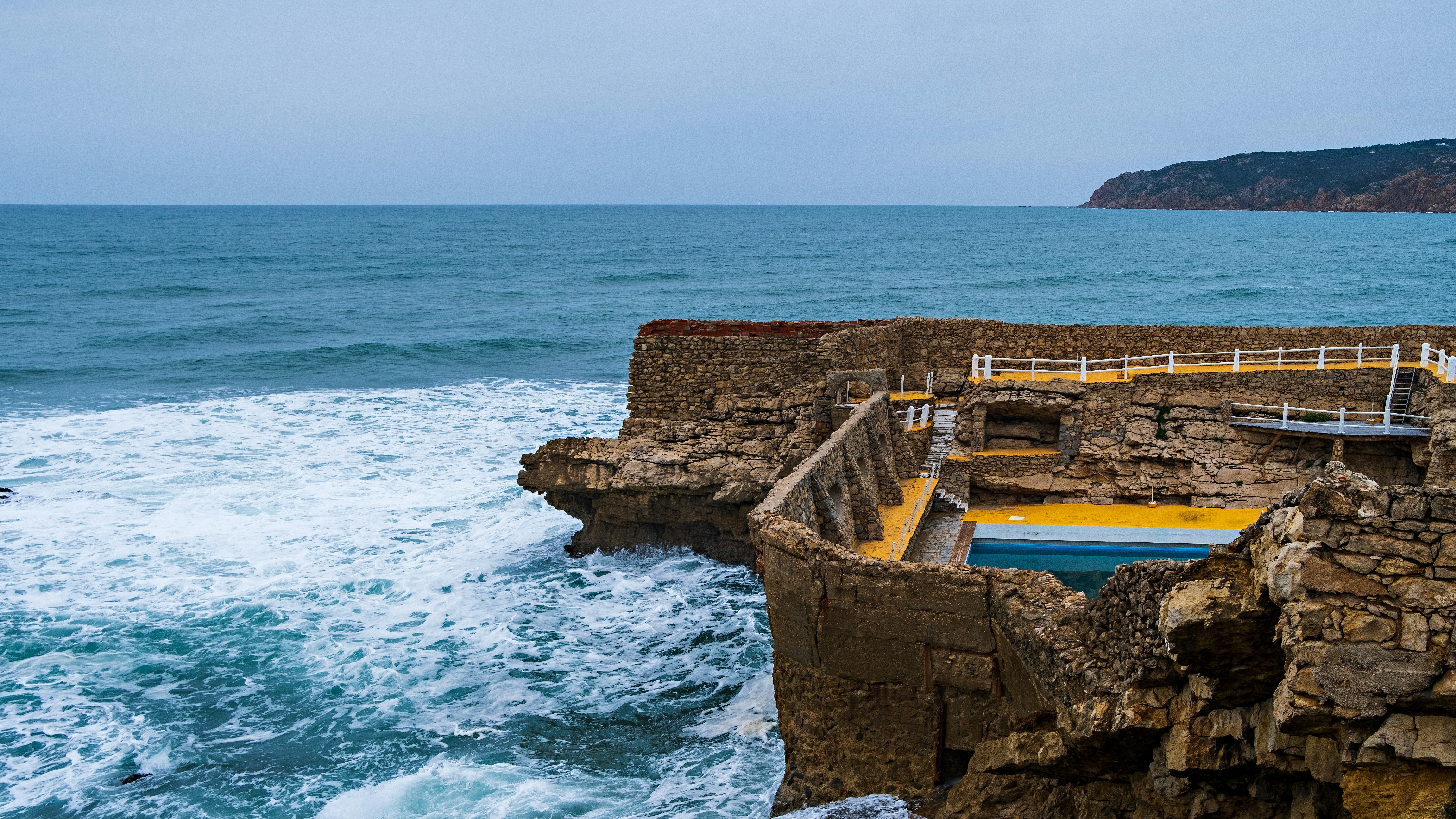 Una scogliera rocciosa si affaccia su uno specchio d'acqua