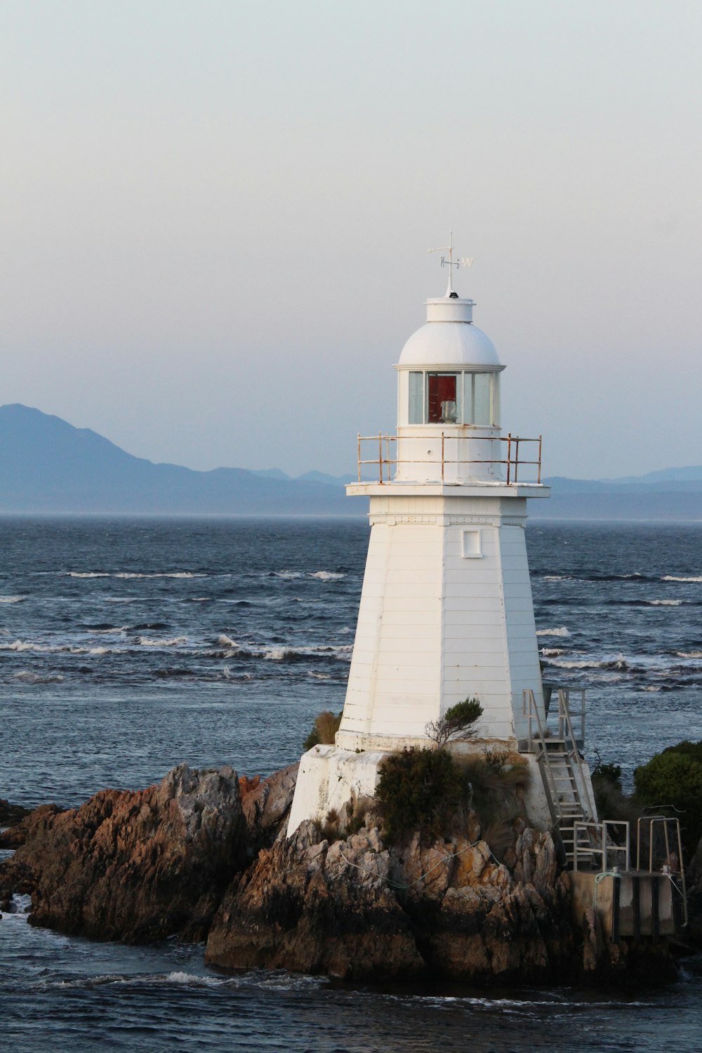 a light house sitting on top of a rock near the ocean