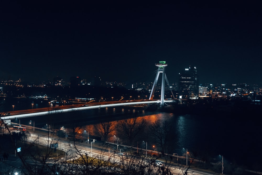 a night time view of a bridge over a river