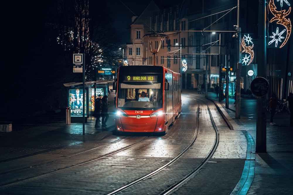 Ein roter Zug, der nachts die Bahngleise hinunterfährt