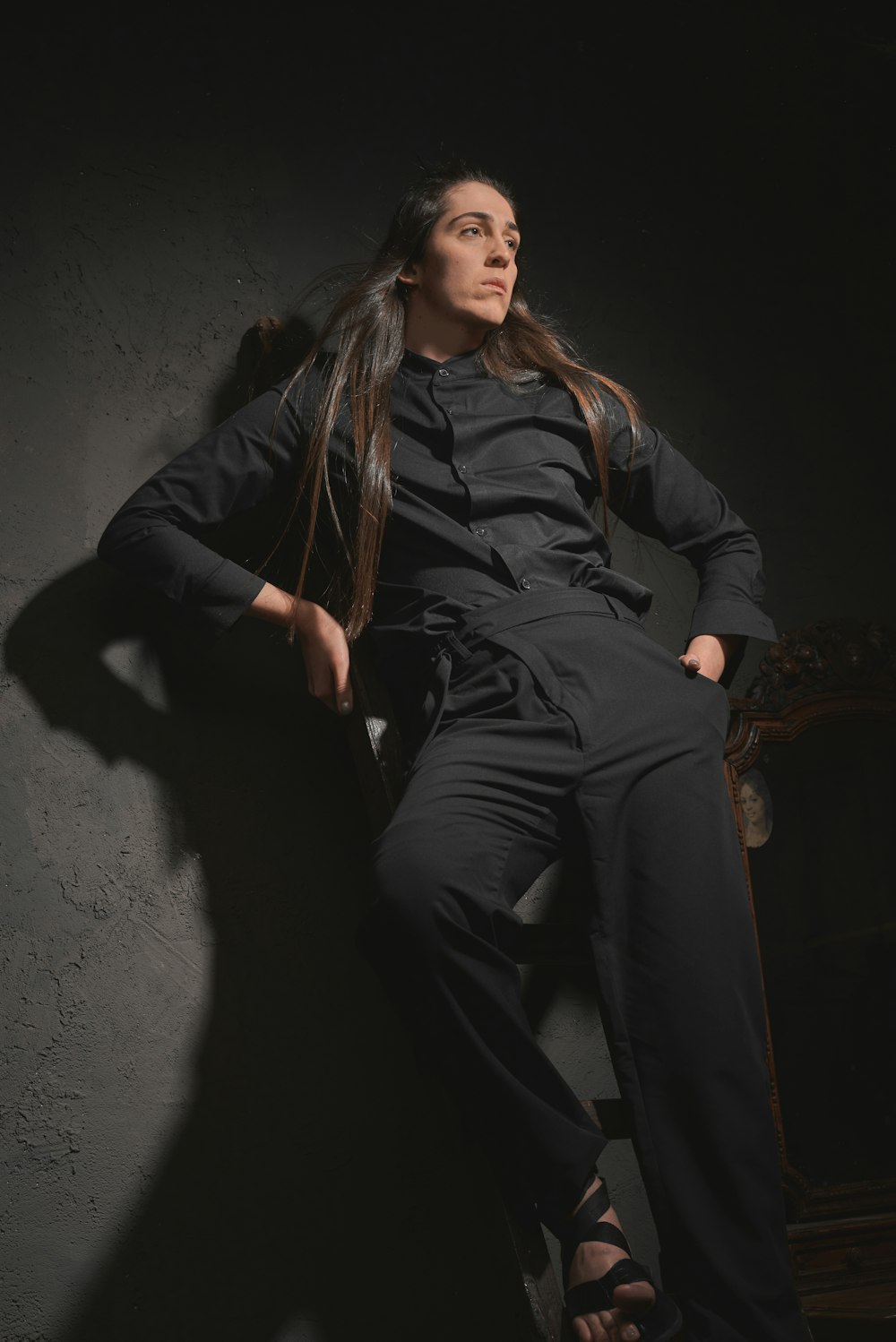 a woman with long hair sitting on a chair
