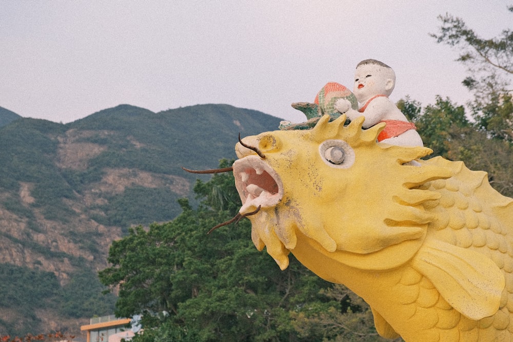 Una estatua de un pez con un niño en su espalda