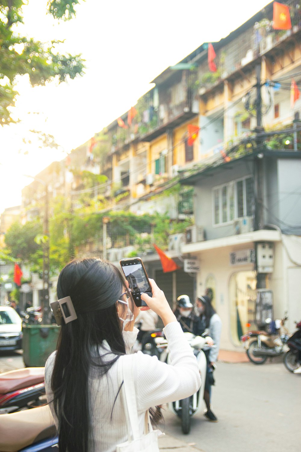 a woman taking a picture of a building with a cell phone