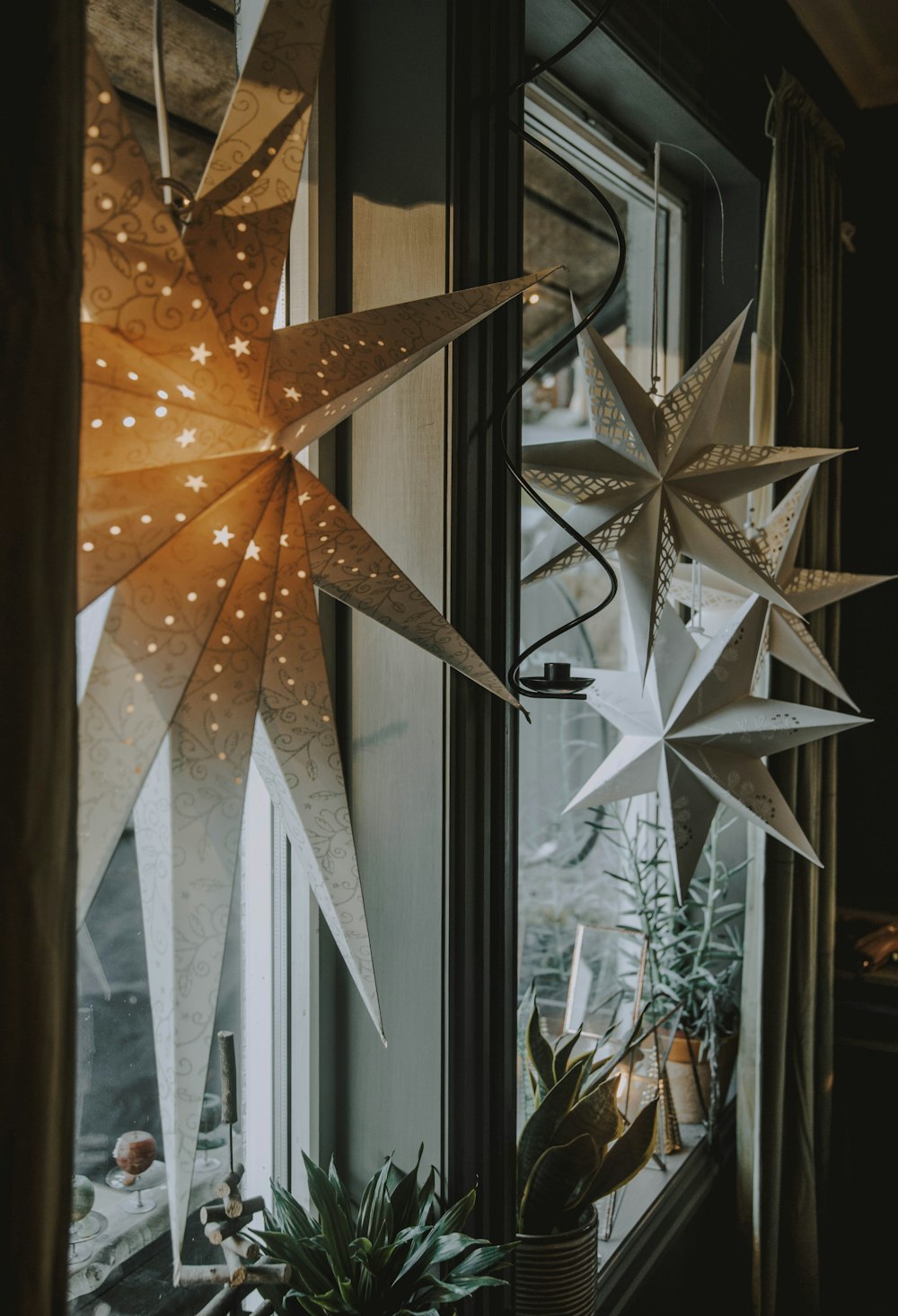 a window sill with two large paper stars hanging from it