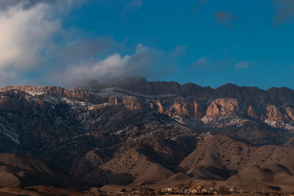 the mountains are covered in snow and clouds