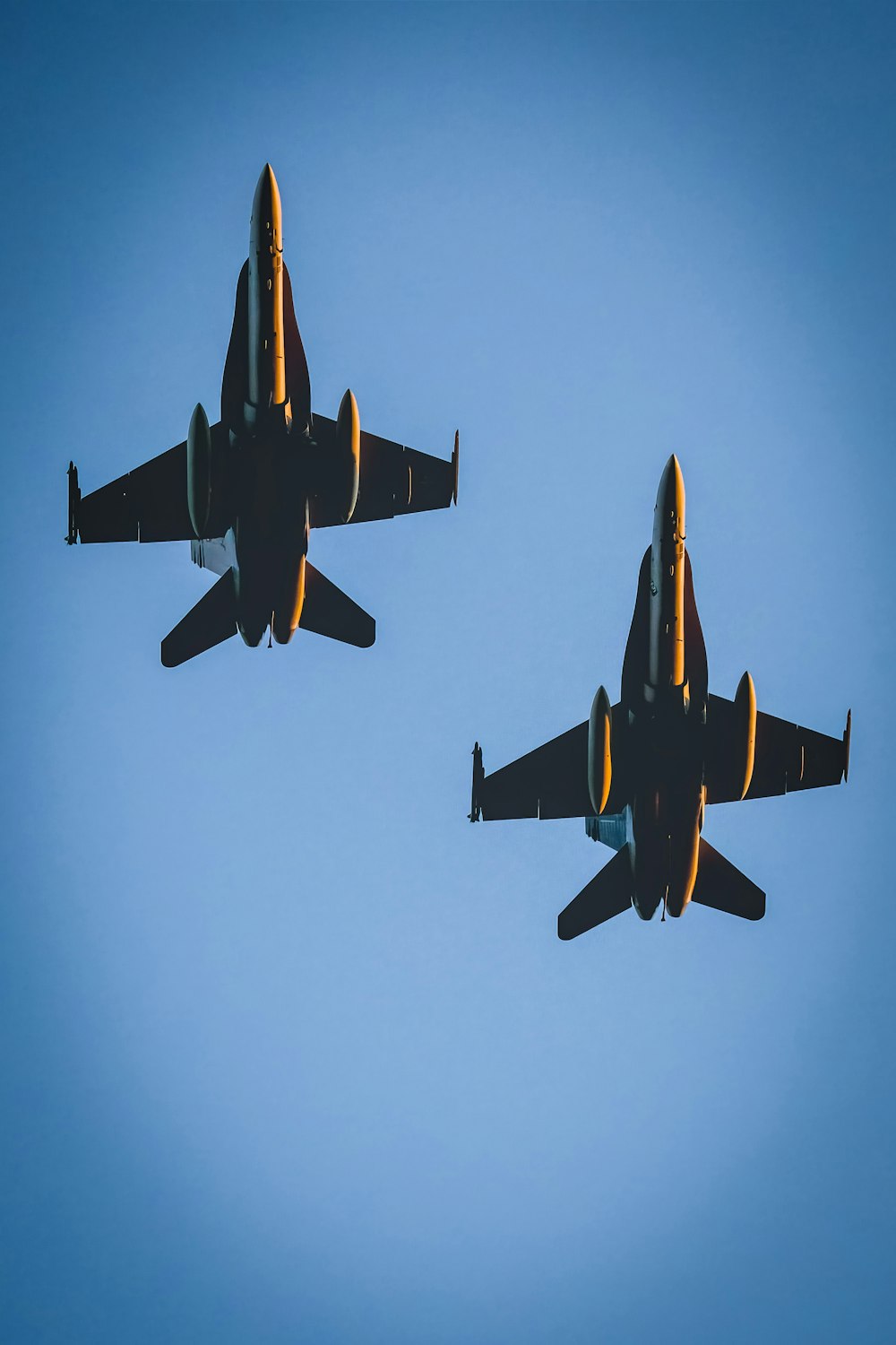 two fighter jets flying in the blue sky