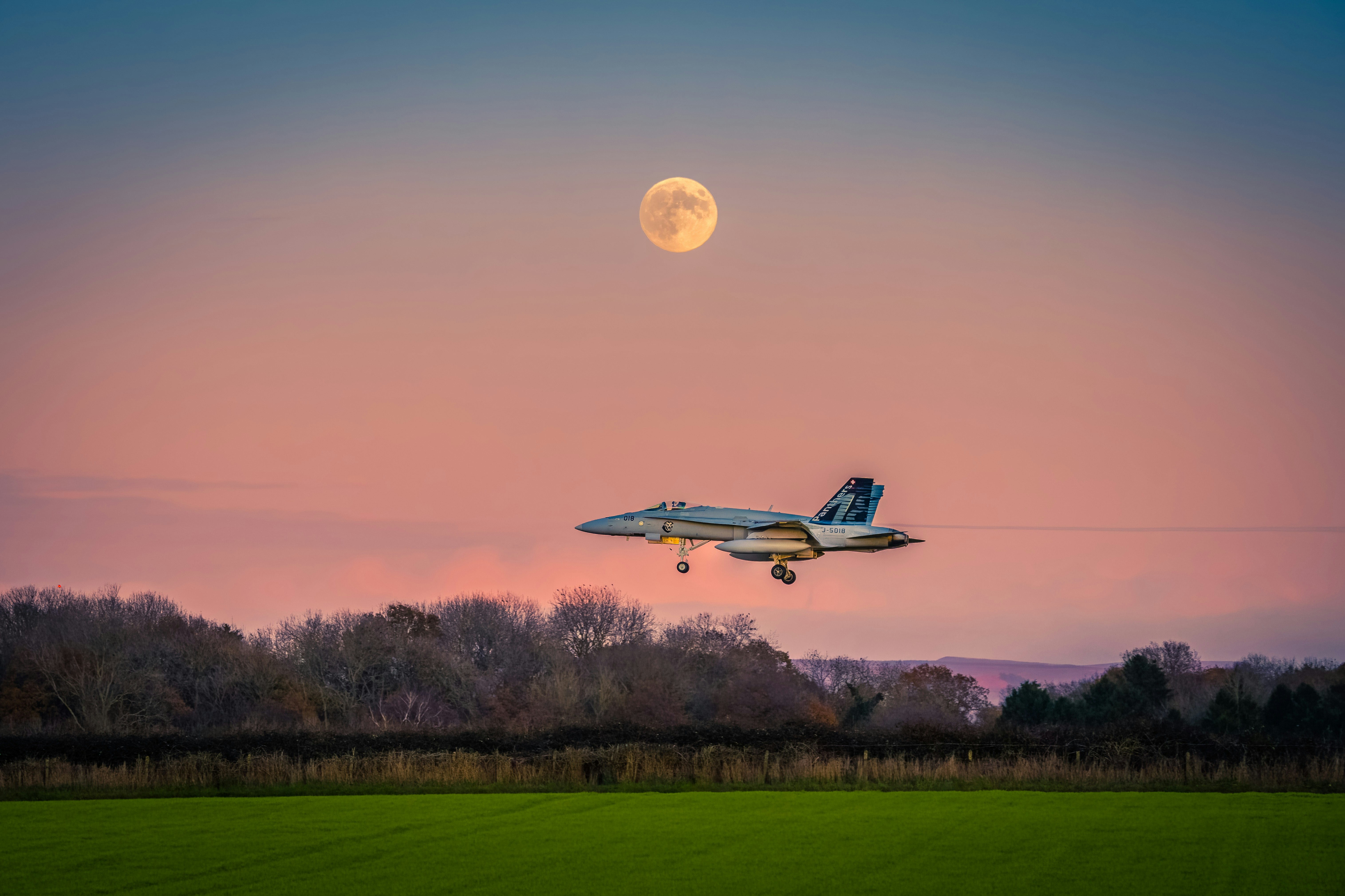 Ein Flugzeug fliegt in der Luft mit einem Vollmond im Hintergrund