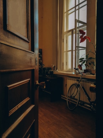 a bicycle is parked in a room with a window