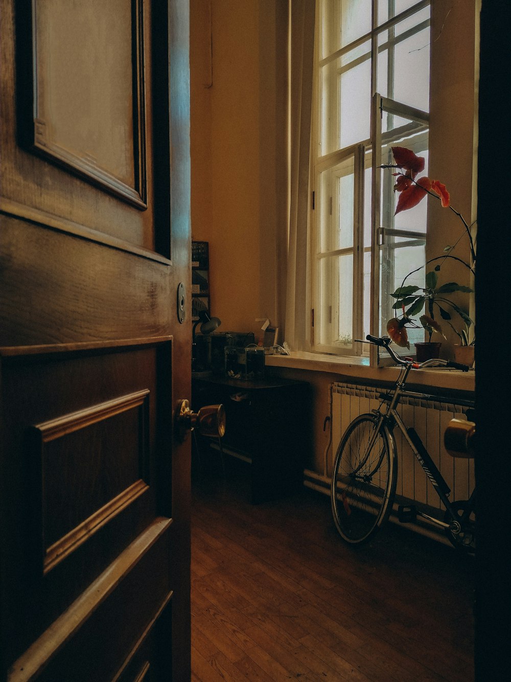 Una bicicleta está estacionada en una habitación con una ventana