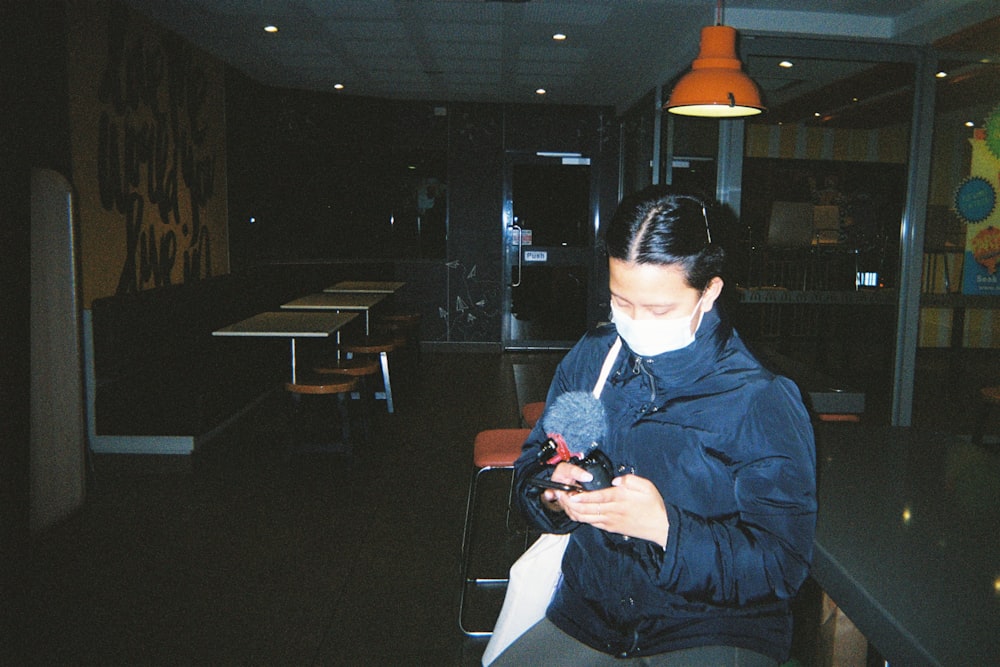 a woman sitting at a table using a cell phone