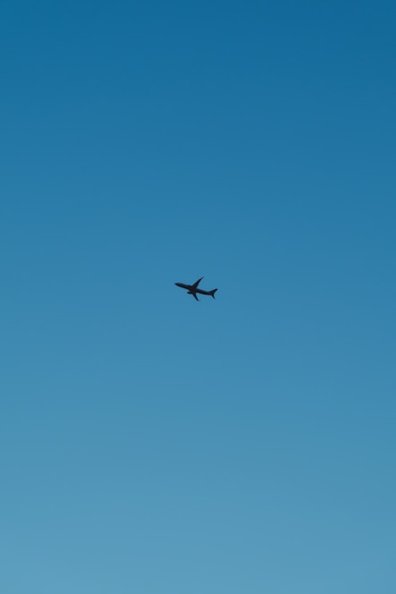 A vibrant image of an airplane taking off against a clear blue sky.