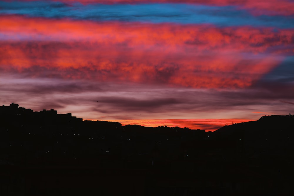 a red and blue sky with some clouds