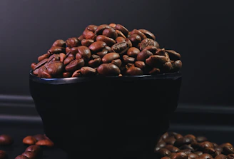 Artfully arranged spices and coffee beans on a matte black surface, softly lit to reveal texture