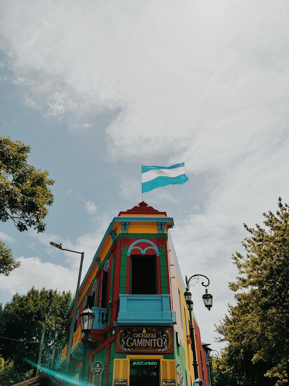 um edifício colorido com uma bandeira em cima dele