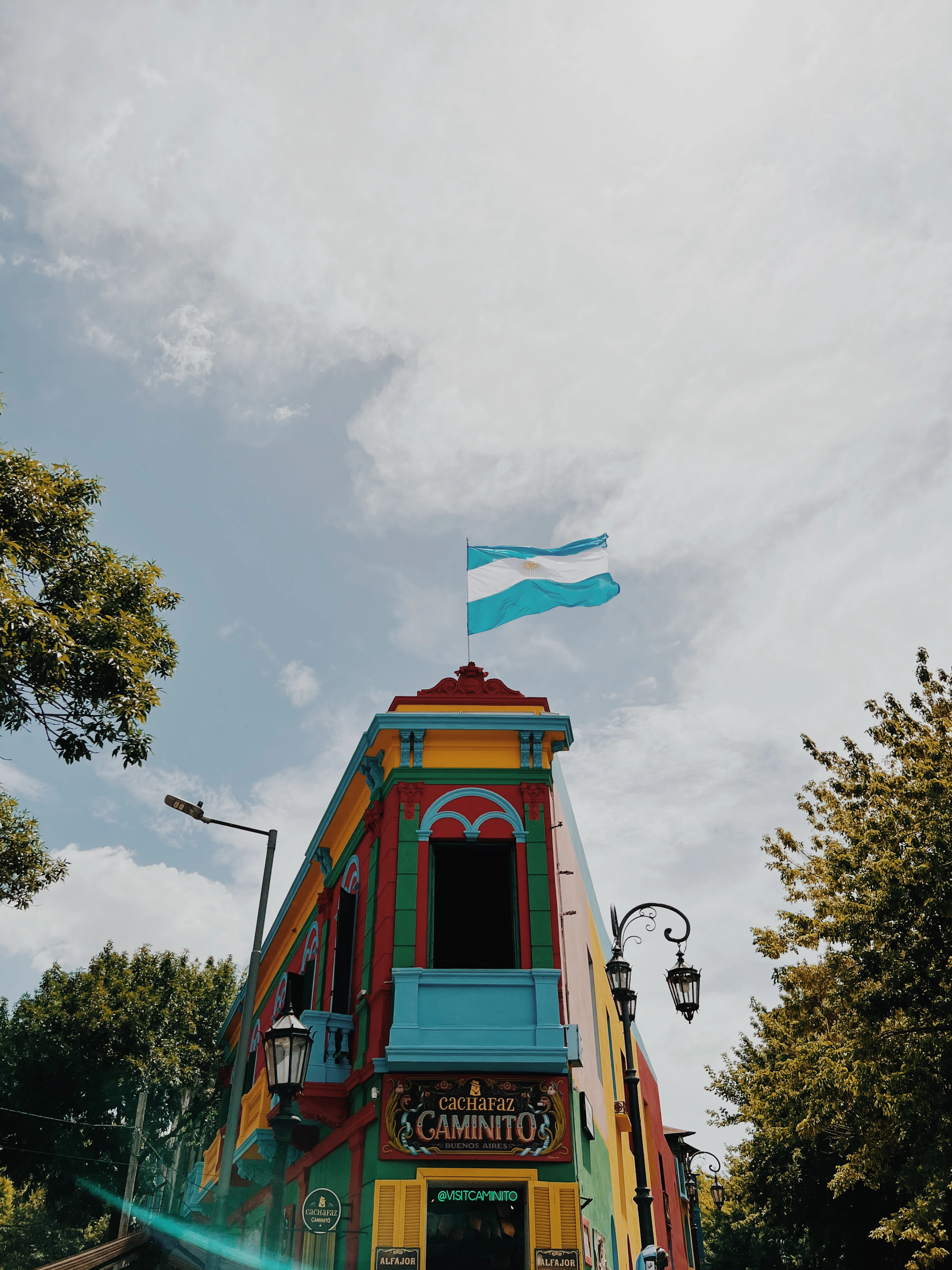 A colorful building on Caminito street in La Boca, Buenos Aires, with an Argentine flag flying above