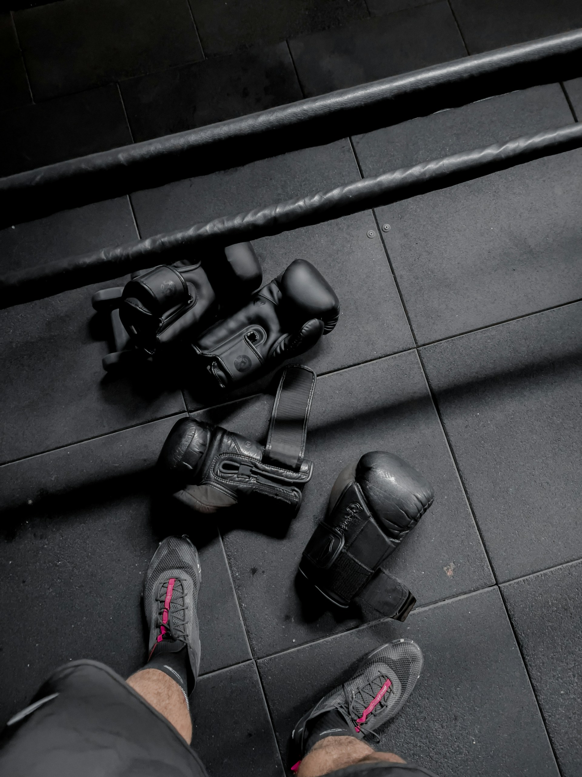 a person standing on a tiled floor next to a pair of black shoes