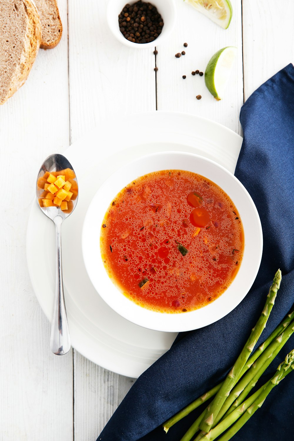 a bowl of tomato soup on a white table