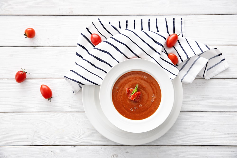 a bowl of tomato soup on a white table