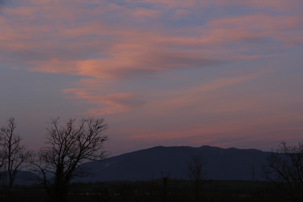 a pink and blue sky with a mountain in the background
