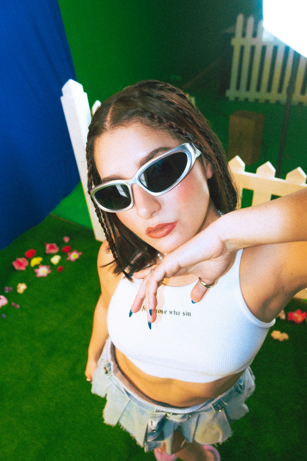 a woman in a white tank top and black sunglasses