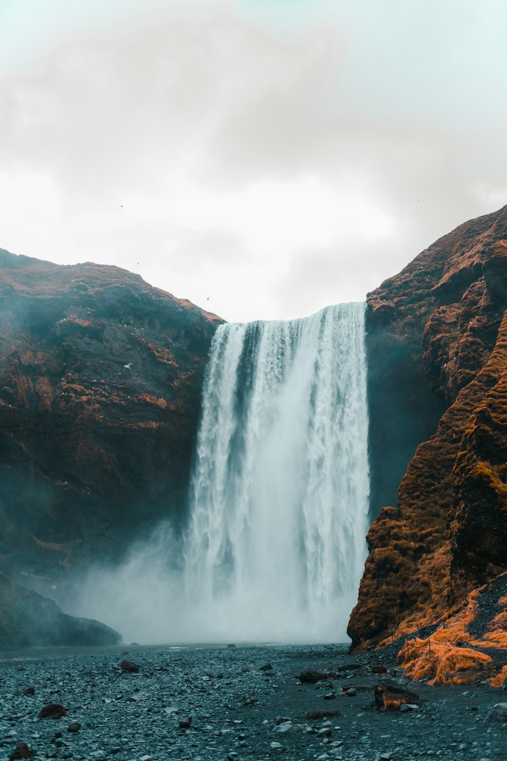 A very tall waterfall in the middle of a mountain photo – Free