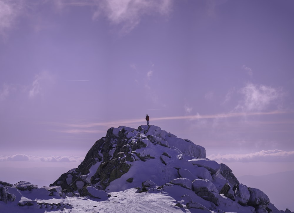 a person standing on top of a snow covered mountain