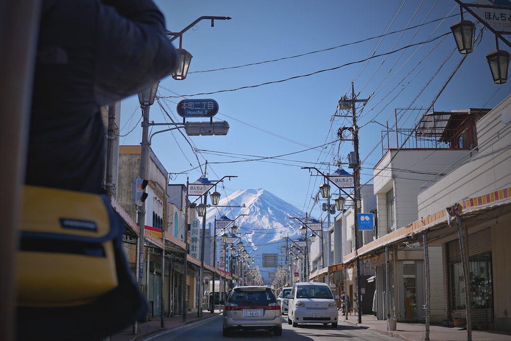 a car driving down a street with a mountain in the background