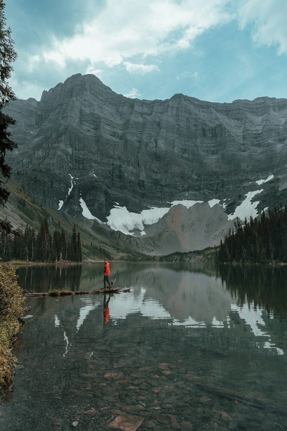 a person standing on a rock in the middle of a lake