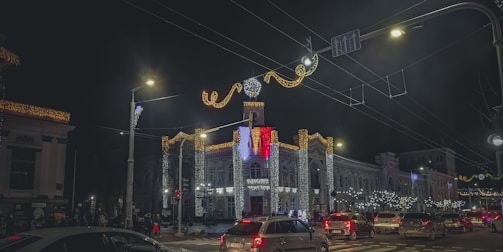 A bustling city street lit up at night with colorful lights and happy tourists.