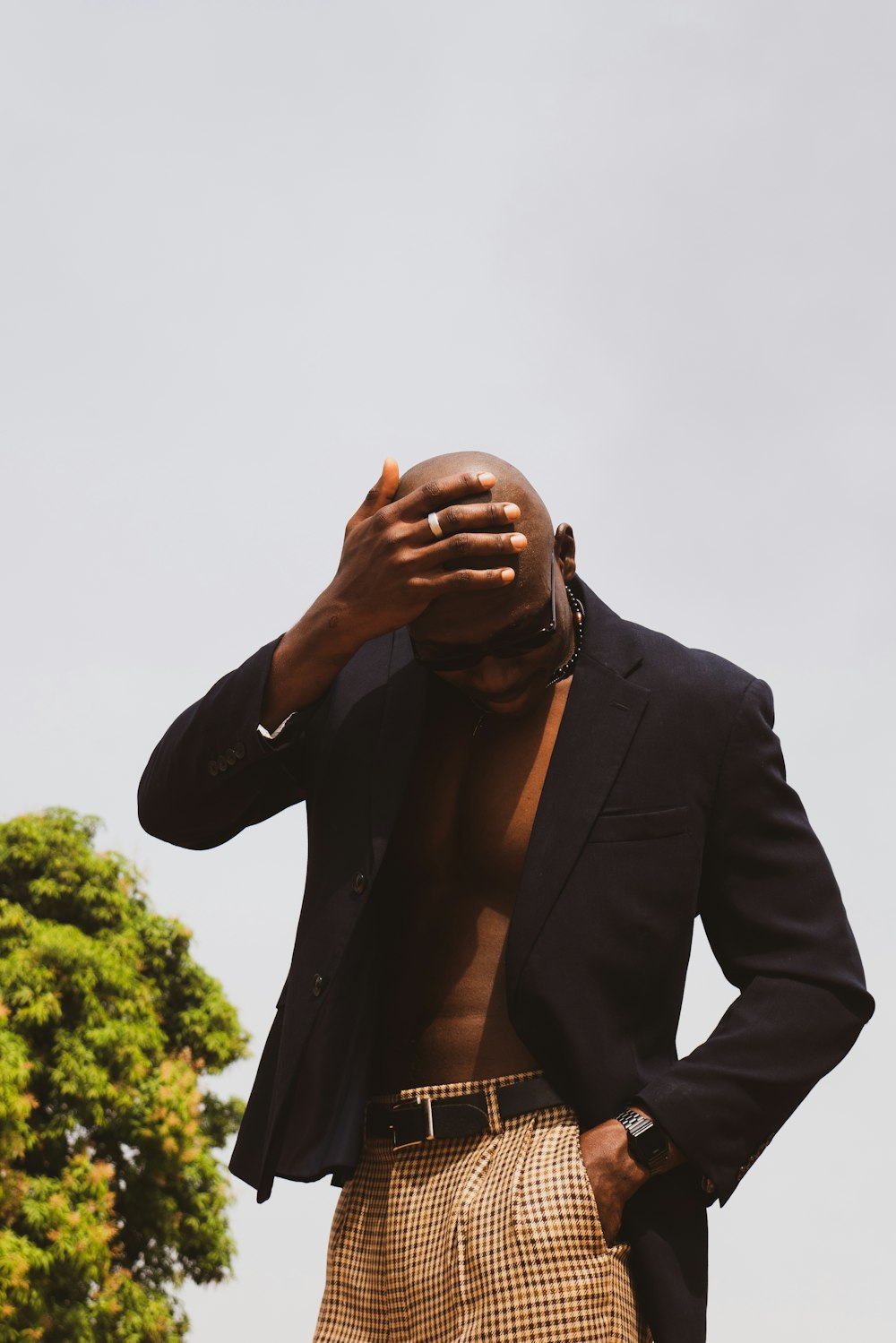 a man in a suit is covering his face with his hands