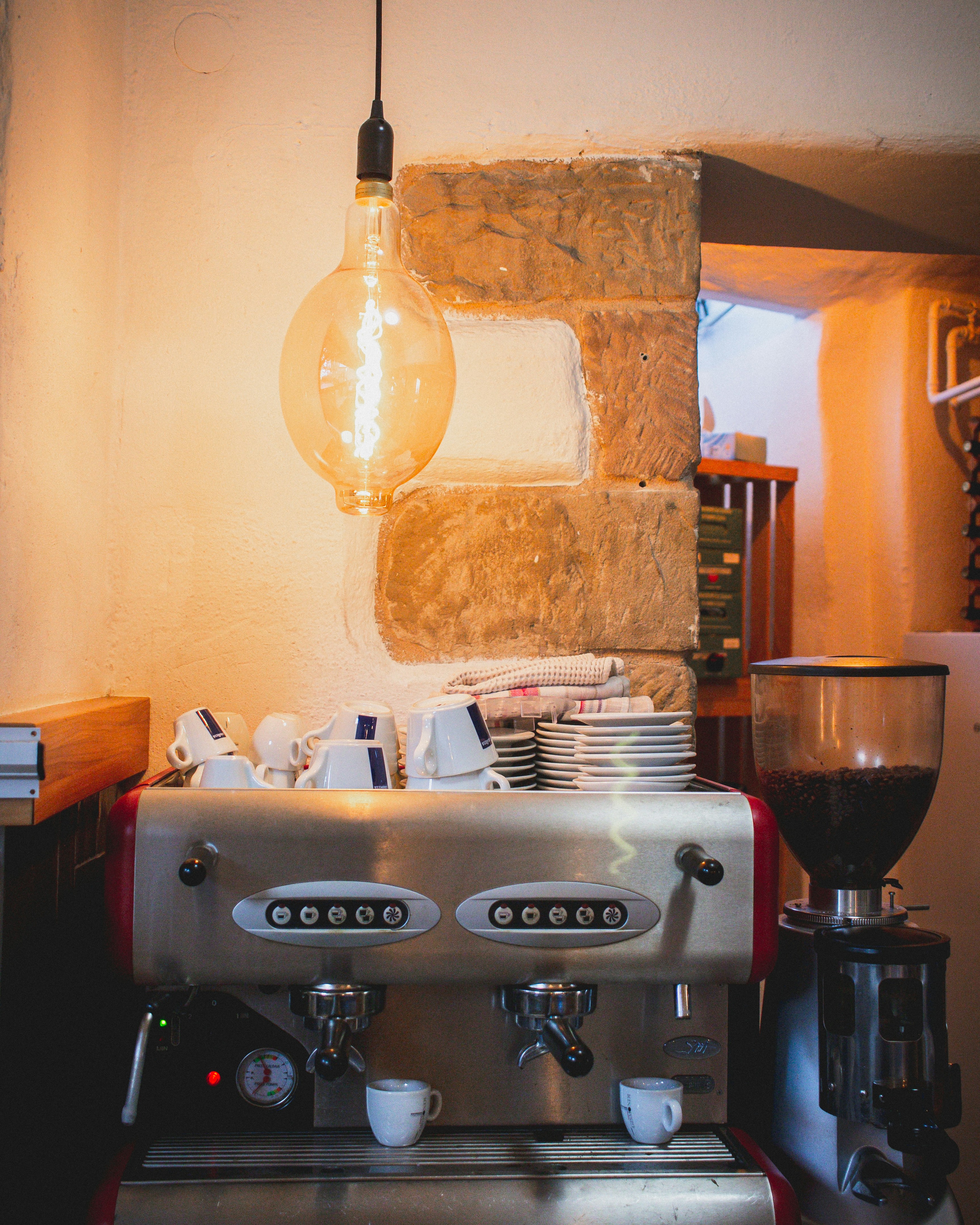 an espresso machine with a light bulb hanging over it