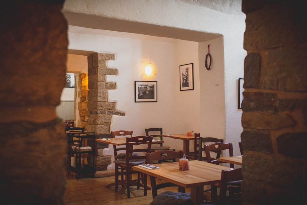 a restaurant with tables, chairs and pictures on the wall