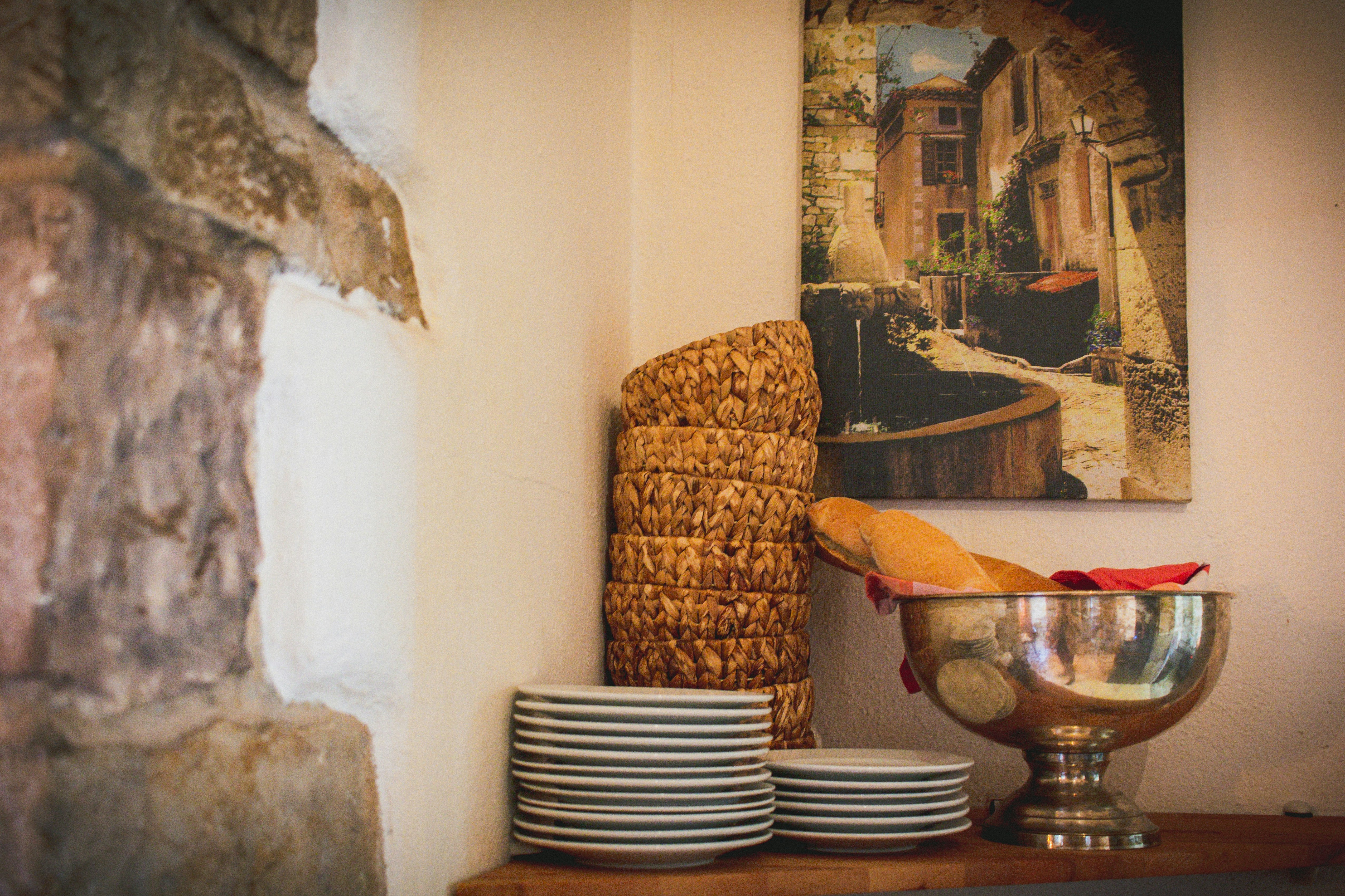 a table topped with plates and bowls next to a painting