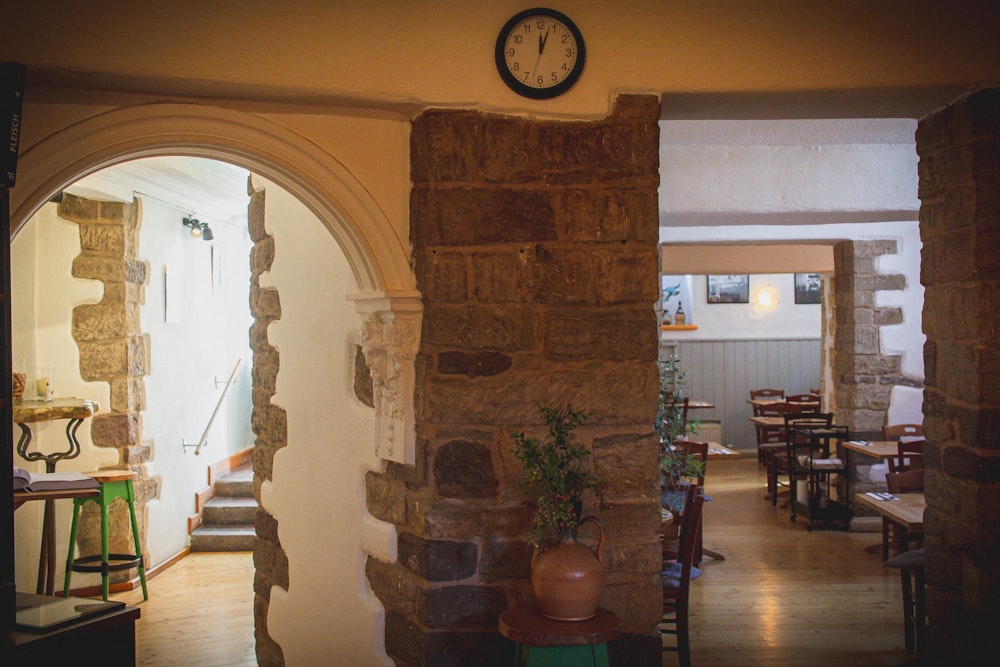 a clock mounted to the side of a stone wall