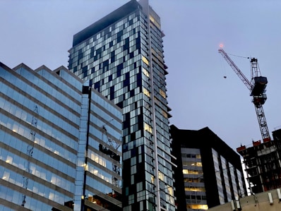 a very tall building with a crane in the background