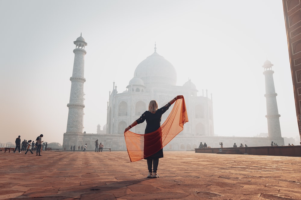 a woman holding a scarf in front of a building